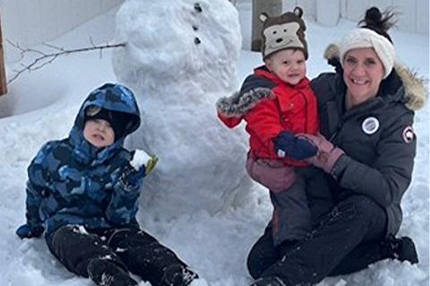 Amanda with her family building a snowman