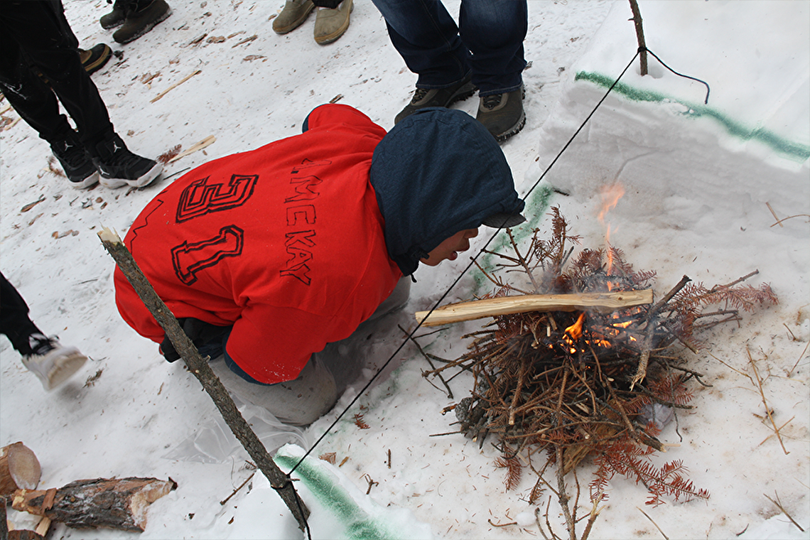Youth building a fire